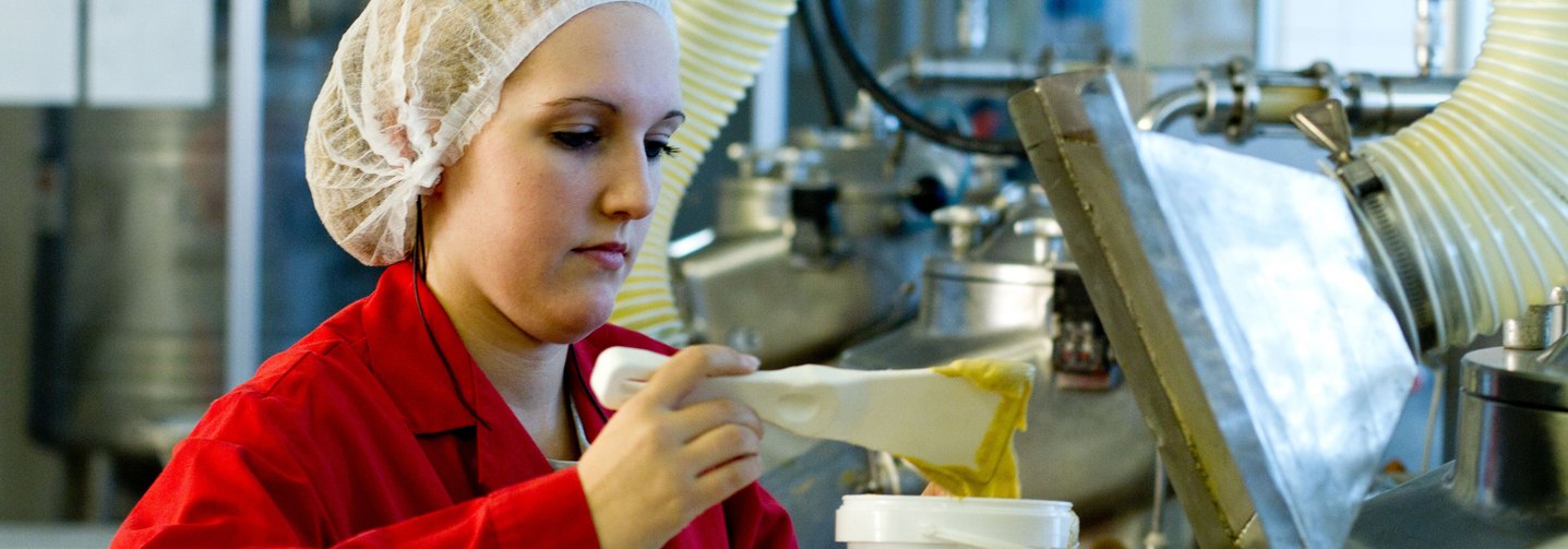 Zur Sicherung der Qualität entnimmt eine Lebensmitteltechnikerin eine Produktprobe.