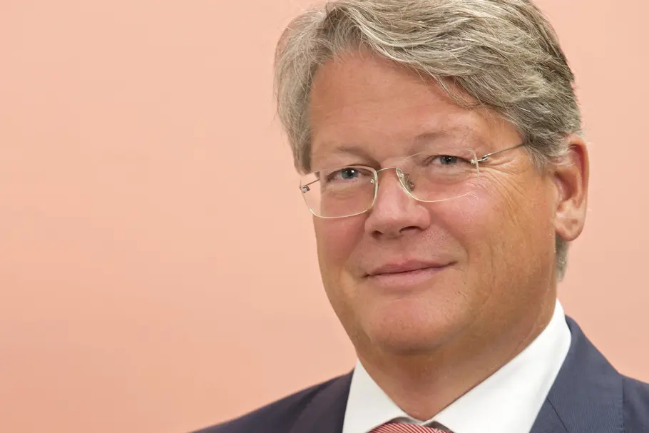Porträt von Hans Peter Andres, Vorstand bei Manner, mit einer Manner Schnitte in der Hand.