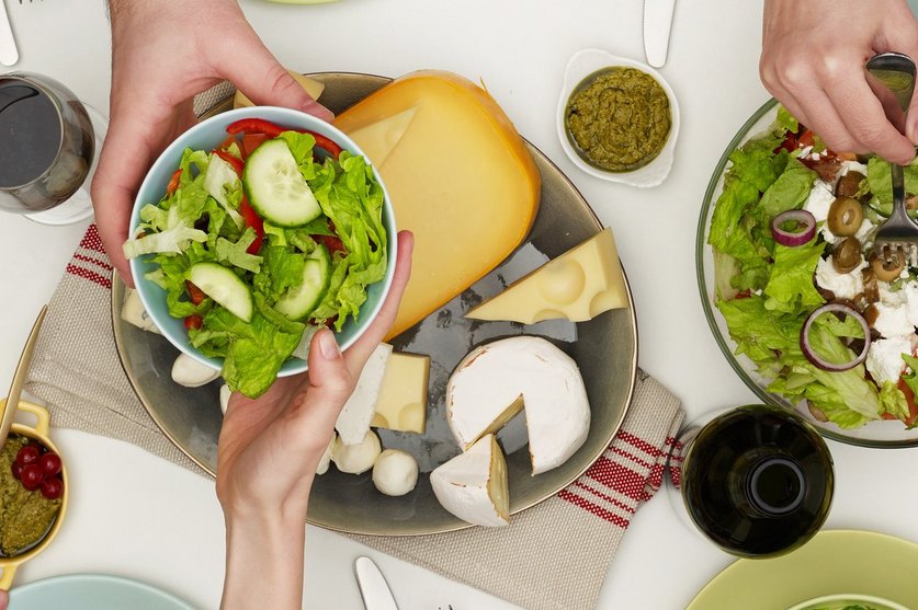 Tisch von oben mit Salat und Käse: Jedes Lebensmittel verfügt über einen spezifischen Nährwert.