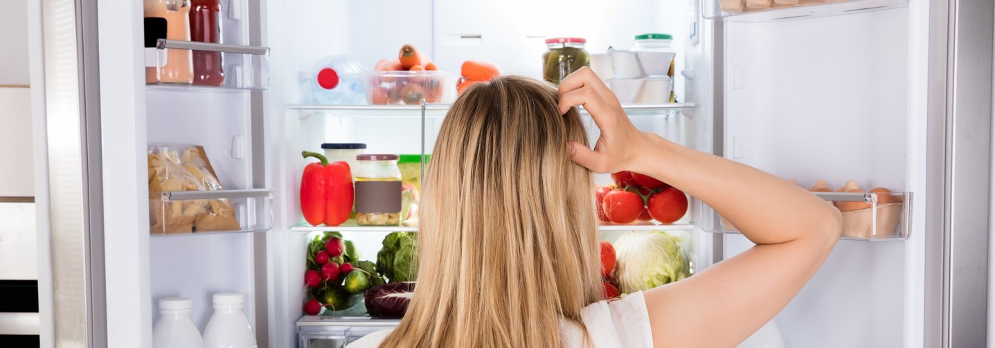 Frau vor Kühlschrank: Jedes Lebensmittel hat seinen Platz.