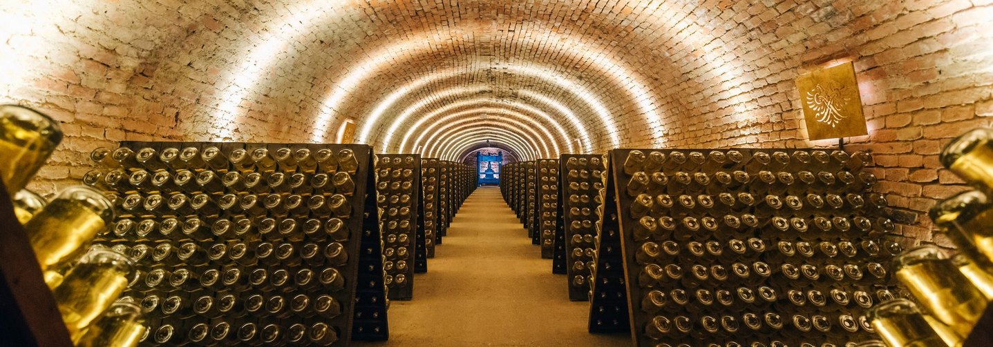 Ein Keller mit Sektflaschen auf Rüttelpulten: Bei der Herstellung von Schaumwein gibt es viele einzelne Schritte.