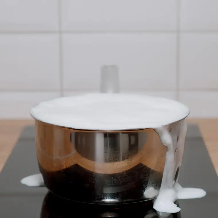 Topf mit überkochender Milch auf dem Herd