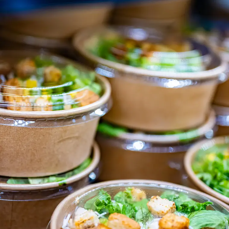 Papierbehälter mit frischen Fertiggerichten im Supermarkt.