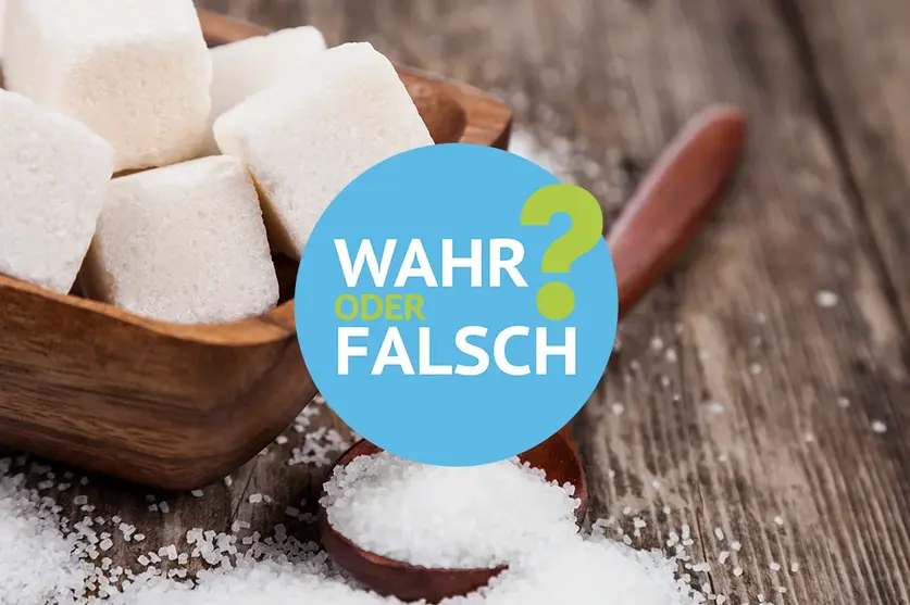 Würfelzucker in einer Holzschale und Streuzucker auf einem Holztisch