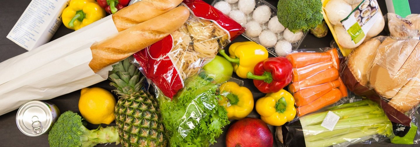 Verschiedene Lebensmittel auf einem Förderband im Supermarkt: Lebensmittel sind in der EU und in Österreich rechtlich klar definiert.