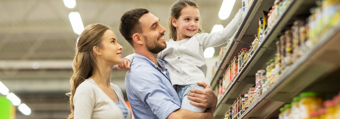 Fröhliche Familie beim Lebensmitteleinkauf im Supermarkt.