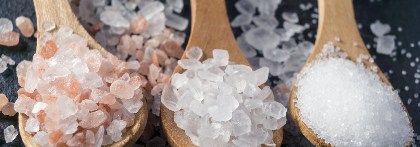 Verschiedene Salze auf Löffeln: Salz erfüllt bei der Herstellung von Lebensmitteln wichtige technologische Funktionen.