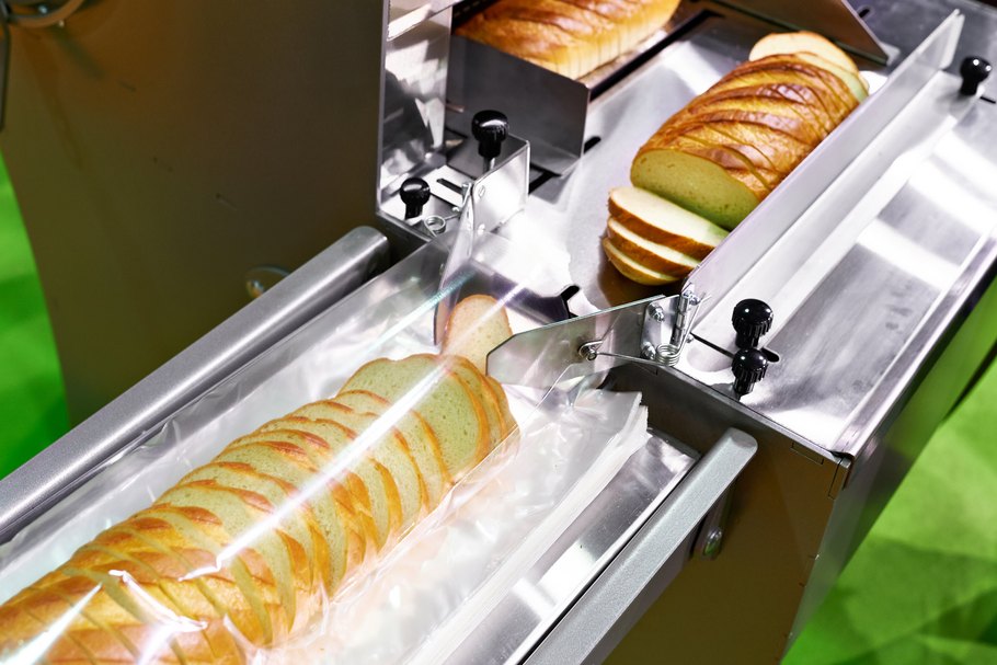 Convenience Food: Eine Maschine schneidet frisches Brot in Scheiben.