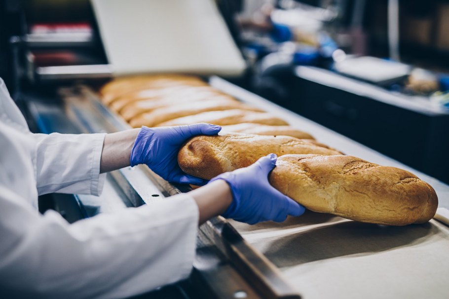 Brotlaibe auf einem Förderband: Um die Herstellung von glutenfreiem Brot zu optimieren, werden die Verfahren laufend verfeinert.