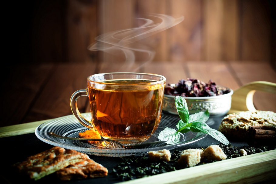 Eine Tasse heißer Tee und Gebäck: Je nach persönlichem Geschmack kann Tee mit Honig, Milch, Fruchtsaft, Zitrone oder Zucker verfeinert werden.