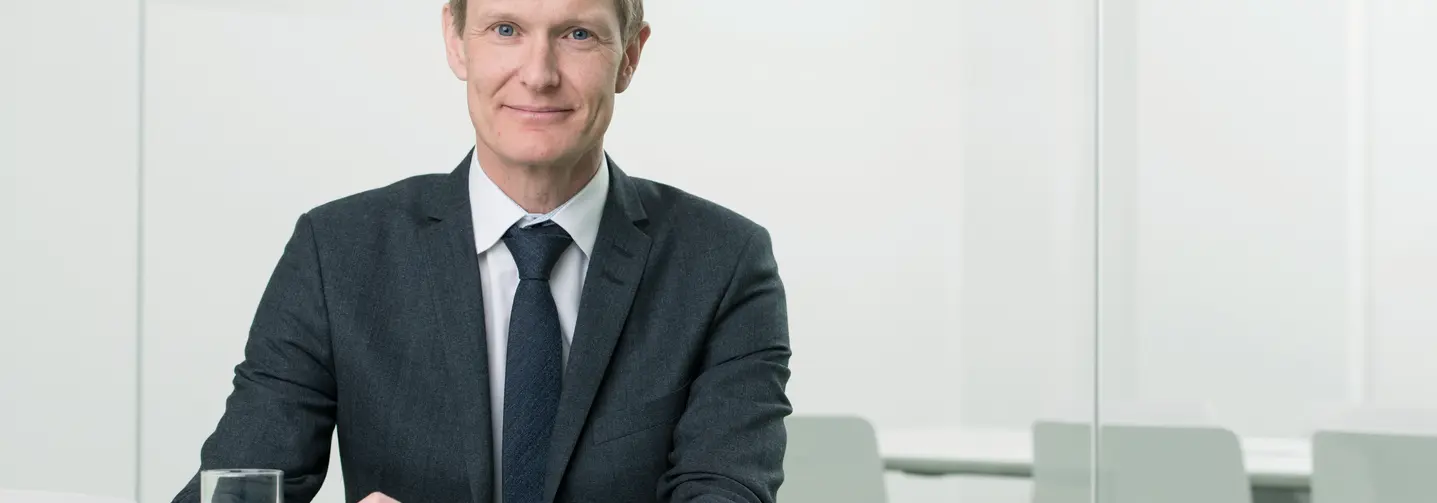 Martin Krasny, Geschäftsführer der AKRAS Flavours GmbH, an einem Schreibtisch sitzend.