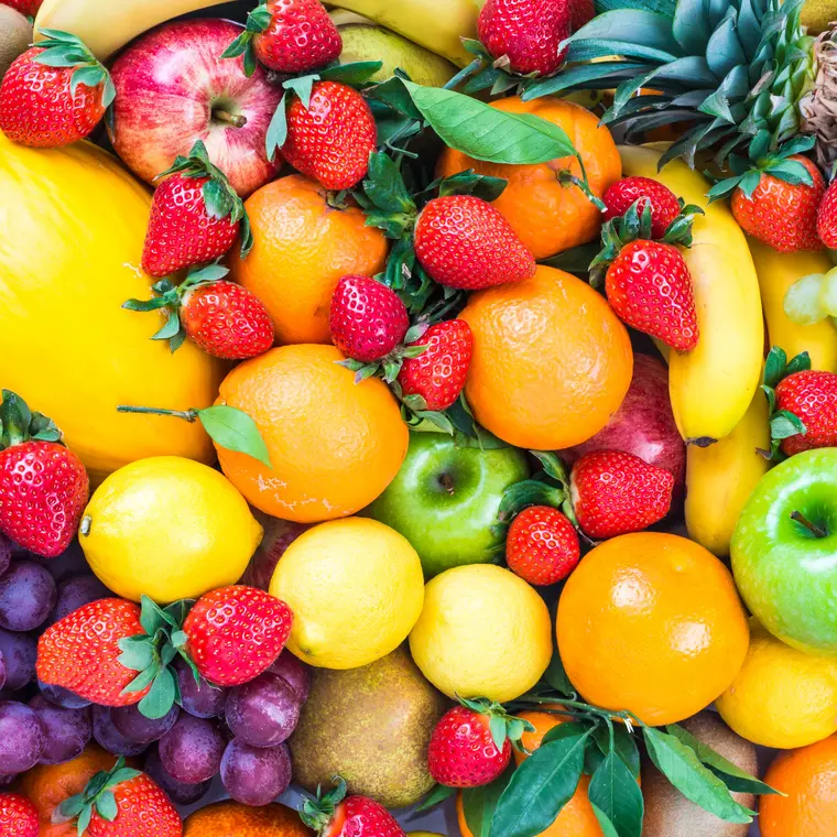 Verschiedene Obstsorten auf einem Untergrund, wie Äpfel, Bananen, Zitronen, Erdbeeren oder Weintrauben.